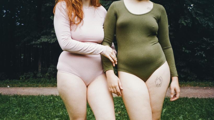 Zwei Frauen in Bodys stehen nebeneinander.