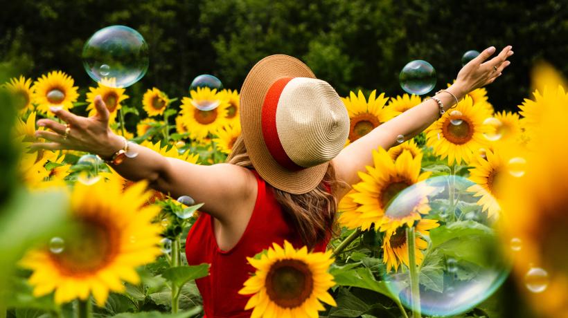 Frau in Sonnenblumen mit Seifenblasen