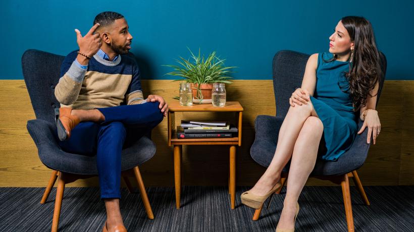 Als Therapeut sollte man auch überlegen, in welchem Rahmen sich der Patient wohler fühlt und Entscheidungen individuell treffen. (Foto: Jopwell – Pexels.com) Mann und Frau sitzend, nebeneinander in Sesseln, kleiner Tisch in der Mitte, im Gespräch.