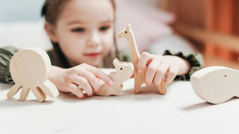Mädchen spielend mit Holzfiguren