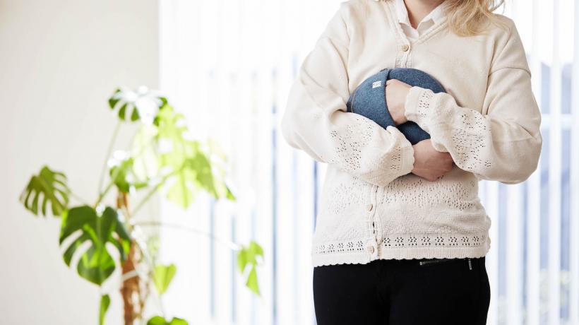 Frau, die das beruhigende Kissen an ihren Bauch hält