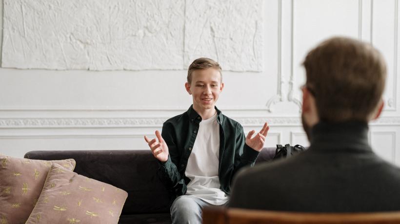 Ein junger Patient und sein Psychotherapeut bei einer Sitzung.