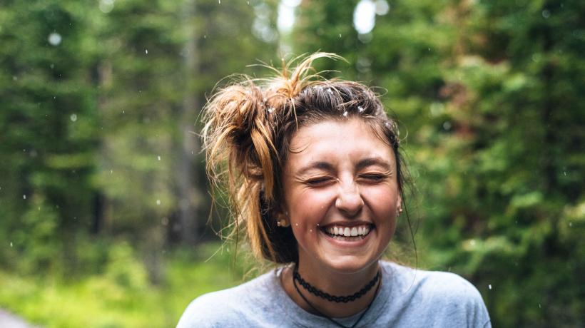 Lachendende junge Frau im Wald
