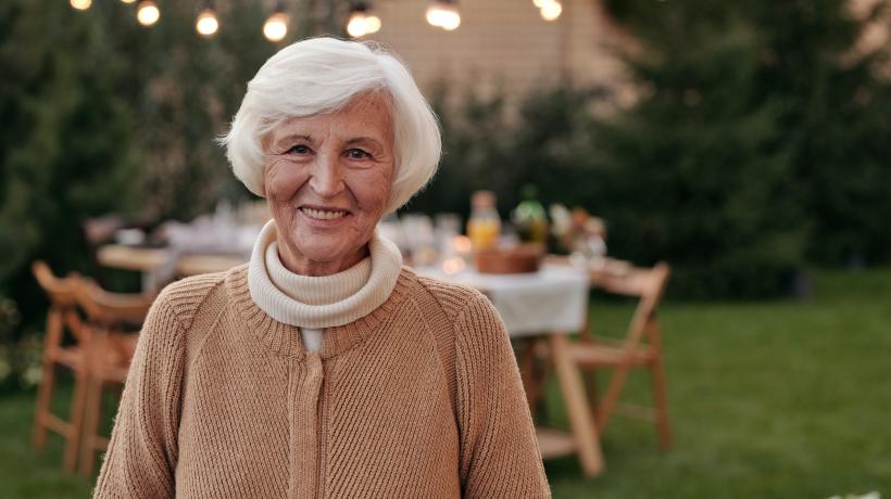 Ältere Frau lächelnd in einem Garten