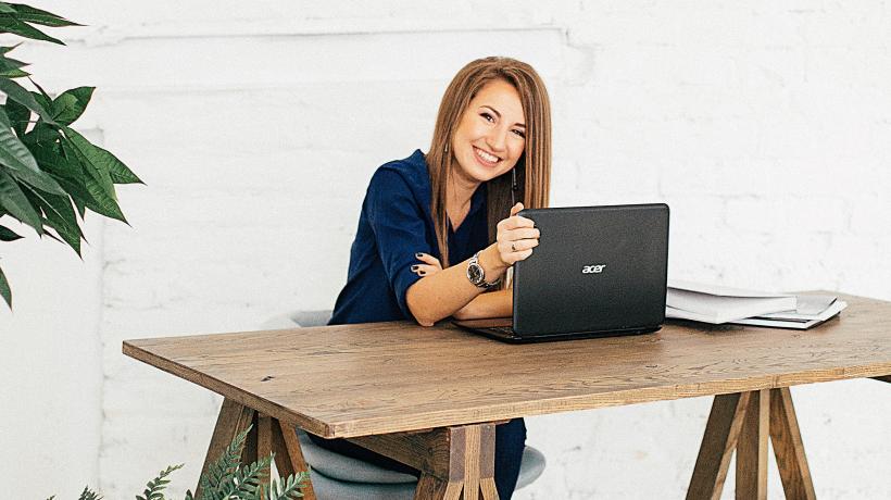 Frau sitzt am Schreibtisch mit Laptop