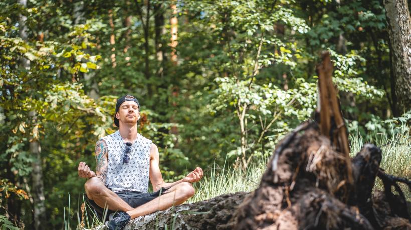 Mann meditiert im Wald
