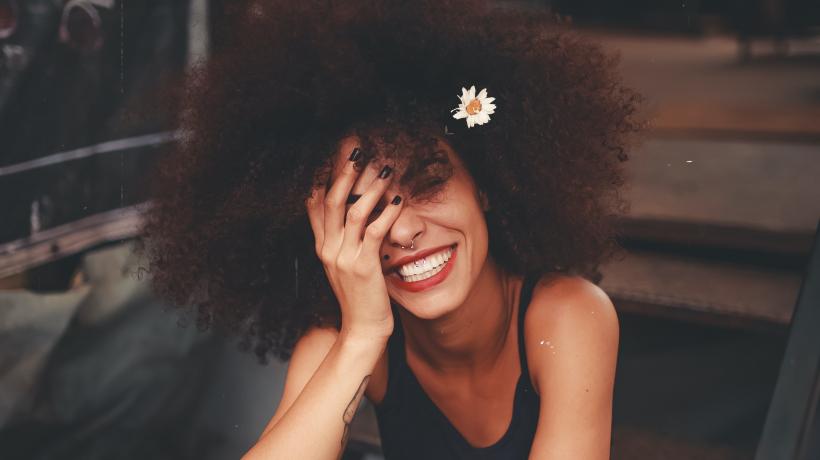 Lachende Frau mit Blume im Haar