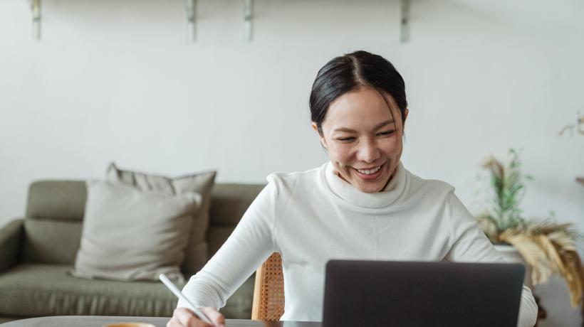Foto: Ketut Subiyanto – Pexels.com Frau sitzt lächelnd vor dem Laptop.