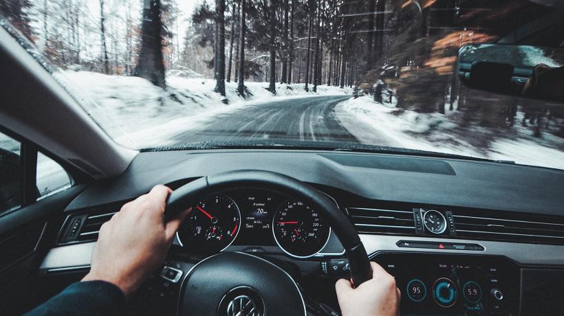 Foto: Jaromir Kavan – Unsplash.com Blick aus dem Cockpit eines Autos auf eine verschneite Landstraße.