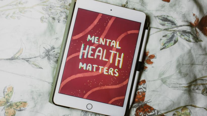 ipad liegt auf Blumendecke. Auf dem Bildschirm ist zu lesen: "Mental Health matters"