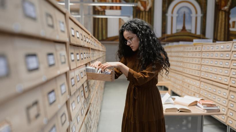 Eine Frau öffnet eine Archivschublade.