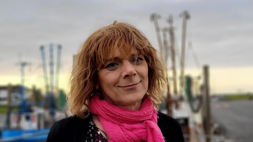 Porträtaufnahme von Sabine Lange, im Hintergrund ist der Hamburger Hafen zu sehen.