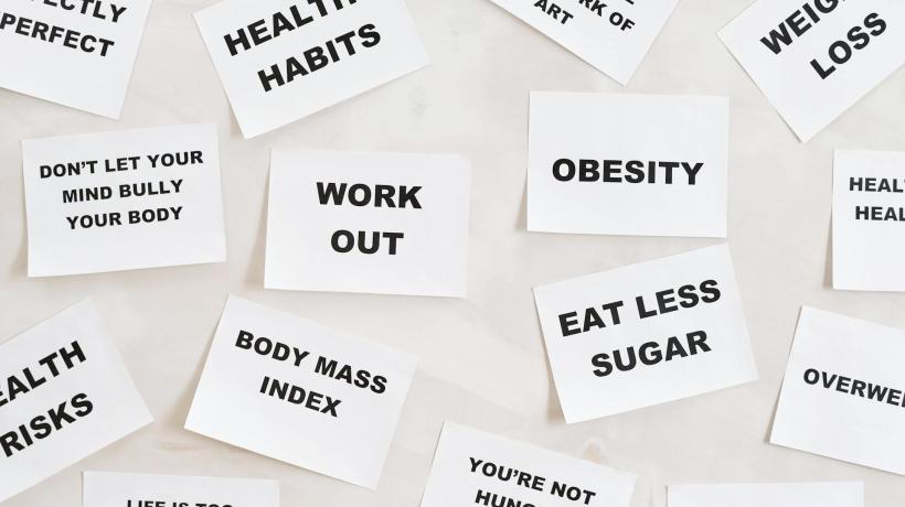 Foto: Moe Mangers – pexels.com Auf einer hellen Oberfläche liegen viele Zettel mit gewichts- und gesundheitsbezogenen Begriffen.