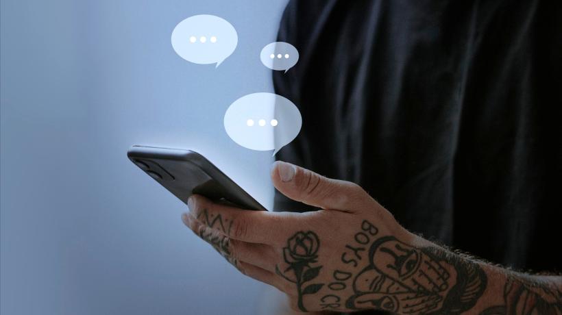 Foto: rawpixel.com – freepik.com Ein Mann hält ein Smartphone in der Hand, drei Sprechblasen sind darüber eingefügt.