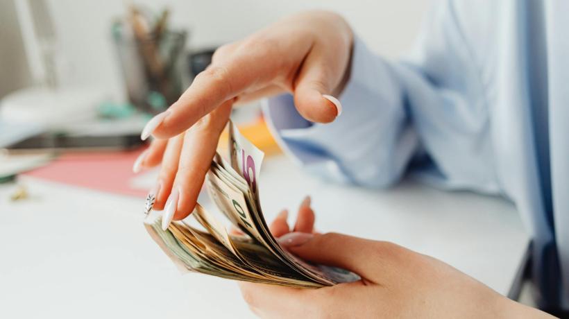 Foto: Kaboompics.com – pexels.com Eine Person blättert durch einen Satz Geldscheine.