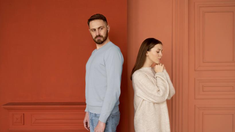 Foto: freepik.com Ein Mann und eine Frau stehen abgekehrt voneinander in einem hellen Raum.