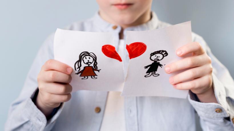 Foto: freepik.com Eine Frau reißt ein Bild auseinander, auf dem eine Frau und ein Mann mit einem Herz gezeichnet sind.
