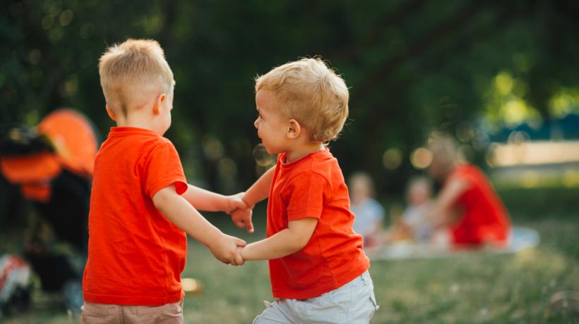 Zwei kleine Jungs halten sich an den Händen.