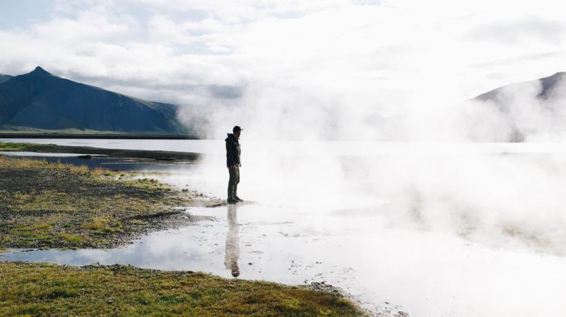 Ein Mann im Nebel an einem See.