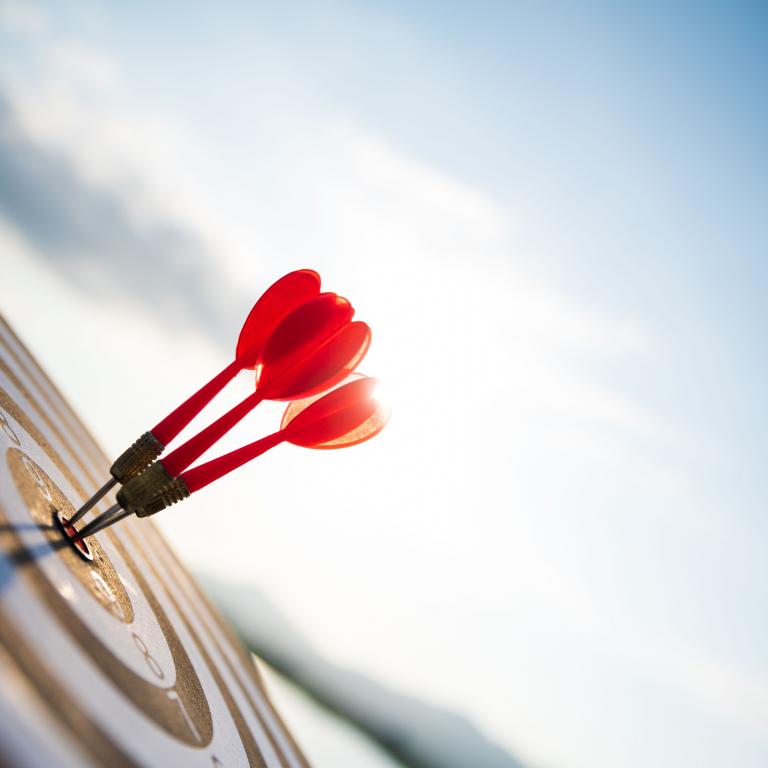 (C) iStock Pfeile stecken in einer Dartscheibe