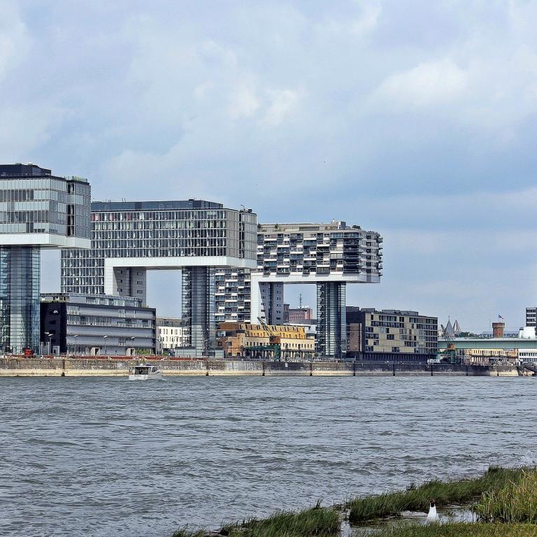 Ansicht der Stadt Köln über den Rhein hinweg. Links mehrere hohe Bürogebäude, rechts hinten der Dom.