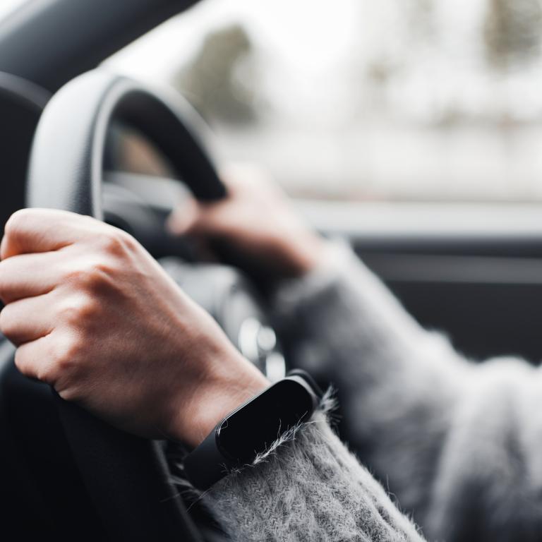Man sieht die Hände eines Autofahrers am Lenkrad