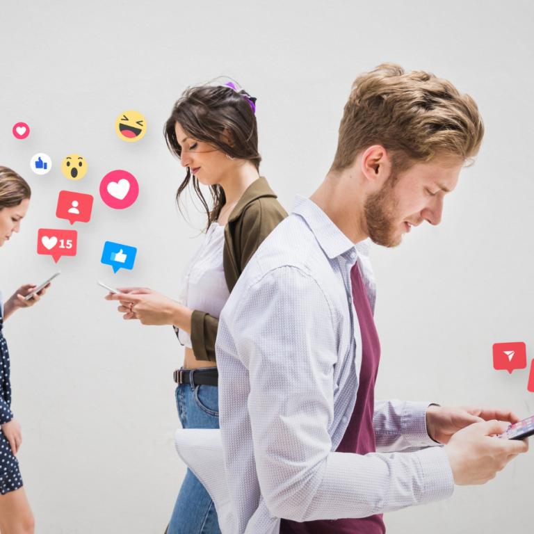 2 Frauen und ein Mann, die auf Ihre Smartphones schauen, von denen Emojis hochsteigen.