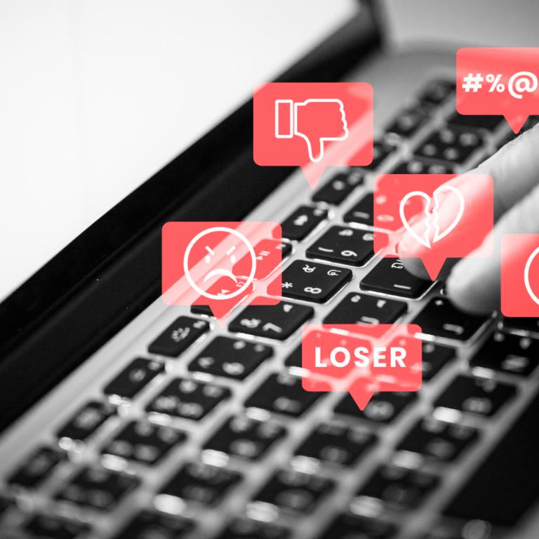 Eine Tastatur mit Hatespeech-Symbolen in Sprechblasen darüber