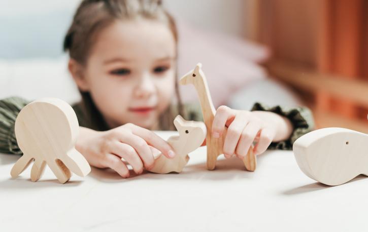 Mädchen spielend mit Holzfiguren