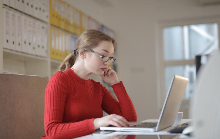 Frau sitzt am Laptop im Büro