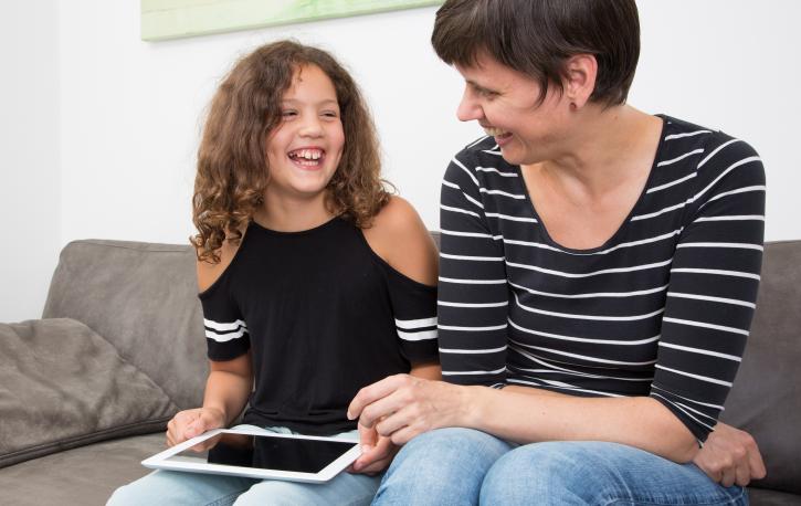 Foto: Sandra Püttmann Ein Mädchen und eine Psychologin schauen auf ein Tablet.