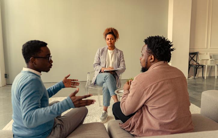 Therapie mit Dolmetscher*innen verläuft anders, aber ist für die Verständigung manchmal essenziell. (Foto: Anthony Shkraba - Pexels.com) Therapiesituation: Zwei Männer sitzen auf einer Couch, ihnen gegenüber sitzt eine Frau auf dem Stuhl. Sie unterhalten sich.