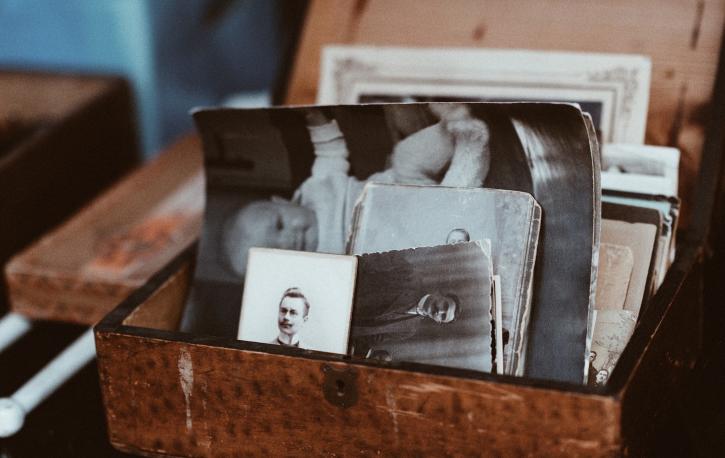 Holzkiste mit alten schwarz-weiß Bildern von Menschen
