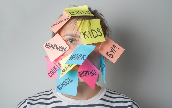 Eine junge Person, deren Kopf mit lauter mit To-Dos beschrifteten Post-its beklebt ist