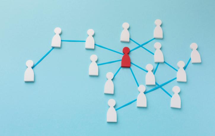 Illustration mit weißen Spielfiguren und einer roten, die mit blauen Linien verknüpft sind