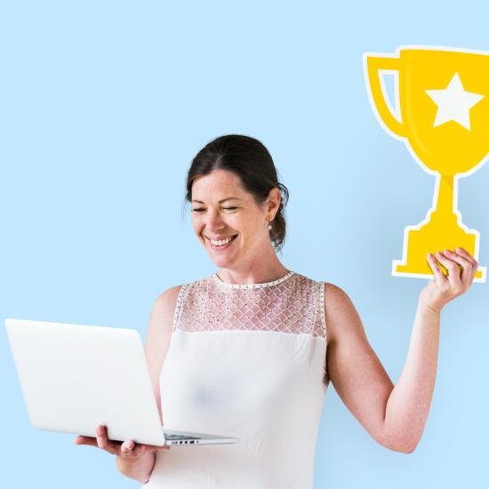 Eine Frau hält einen Papp-Pokal hoch.