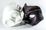 zwei Theatermasken, eine weiße, eine schwarze liegen nebeneinander