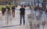 mann auf einer straße alleine, menschen um ihn herum als schatten