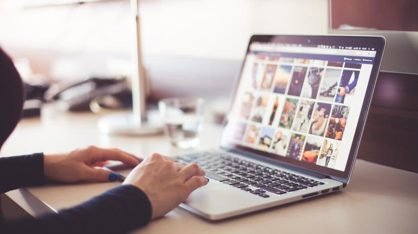 Person schaut Bilder auf Computer an
