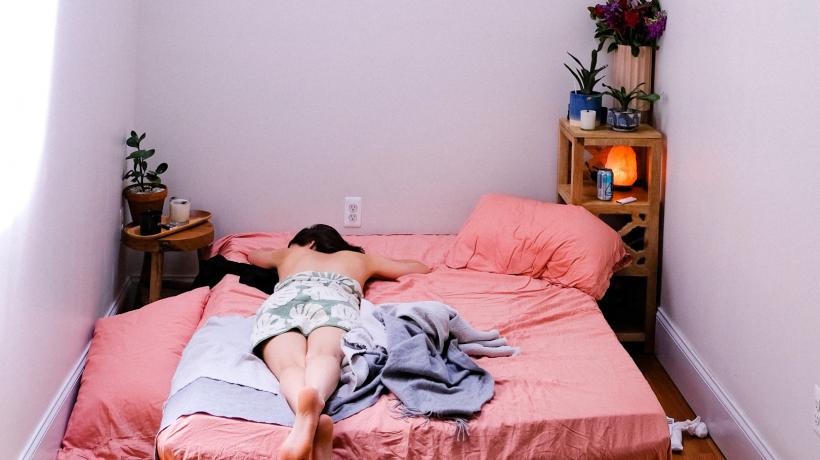 Frau liegt auf dem Bett