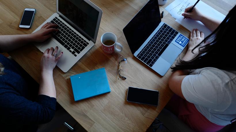 Zwei Menschen vor Laptops