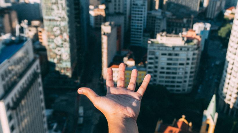 Hand zu einer Skyline hin ausgestreckt