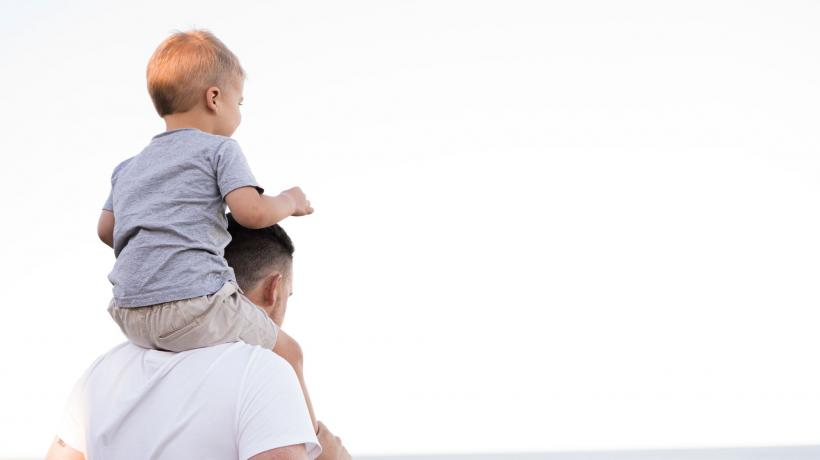 Kind sitzt bei seinem Vater auf den Schultern