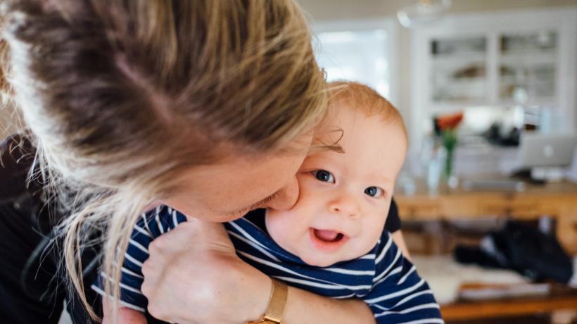 Baby bekommt Kuss von Mama