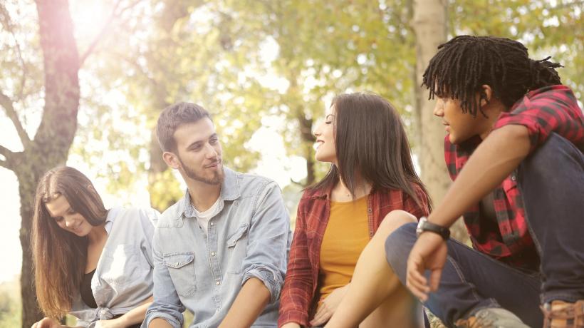 Vier junge Menschen sitzen nebeneinander