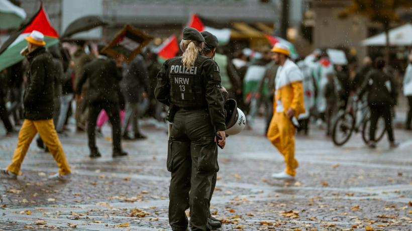 Zwei Polizist:innen stehen am Rande einer Demonstration.
