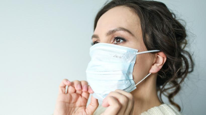 Frau zieht sich ihre Maske zurecht.