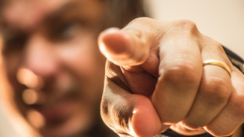 Mann zeigt wütend mit dem Zeigefinger direkt in die Kamera.
