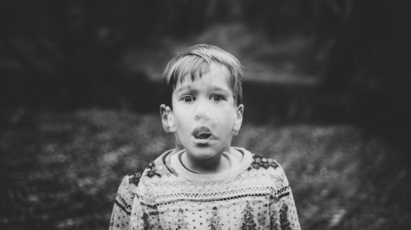 Verzerrtes Bild von kleinem Jungen, der ängstlich schaut, den Mund wie zum Schreien geöffnet.