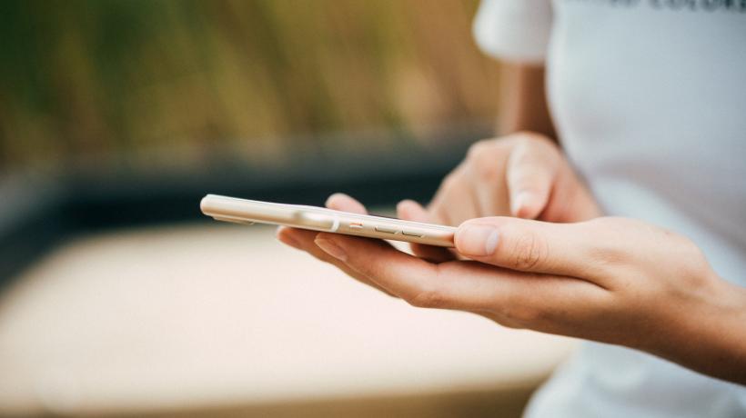 Eine Person hält ein Smartphone in der Hand.